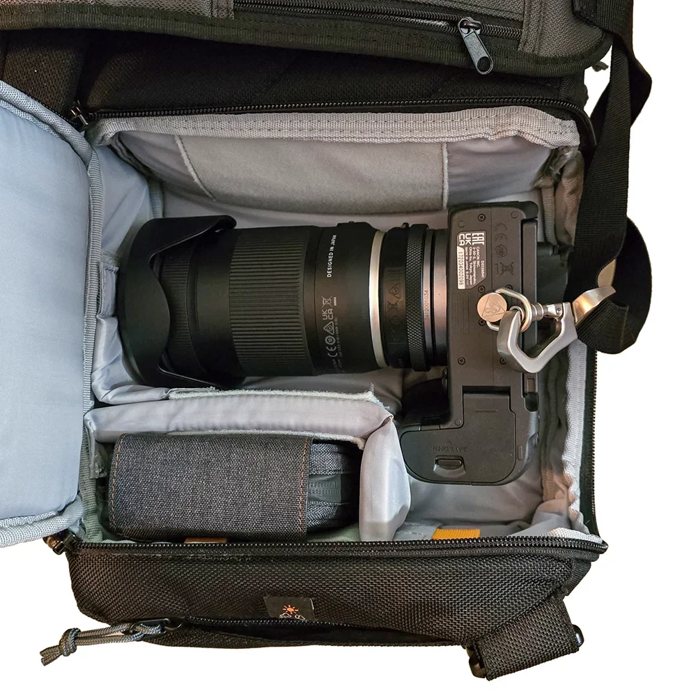 Inside the camera compartment: a Canon R7 body with a Tamron 18-300mm lens attached, snug against padded dividers