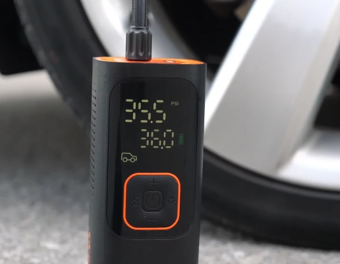 The Skight inflator's LCD reading 35.5 PSI against a target of 36.0 while inflating a car tire