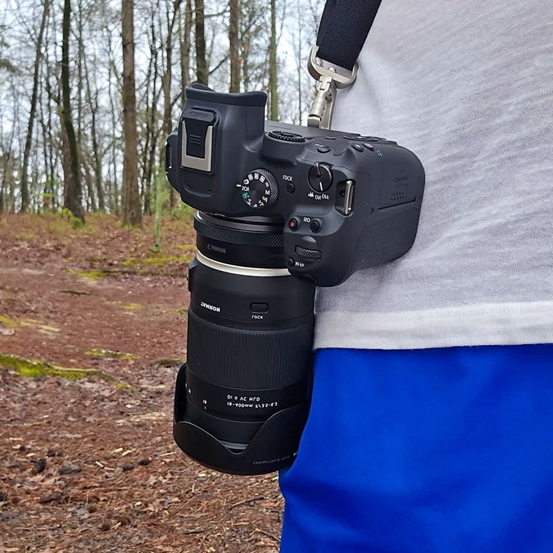 Canon R7 with a Tamron 18-400mm lens riding at the hip on the Danger Buddies strap on a forest trail